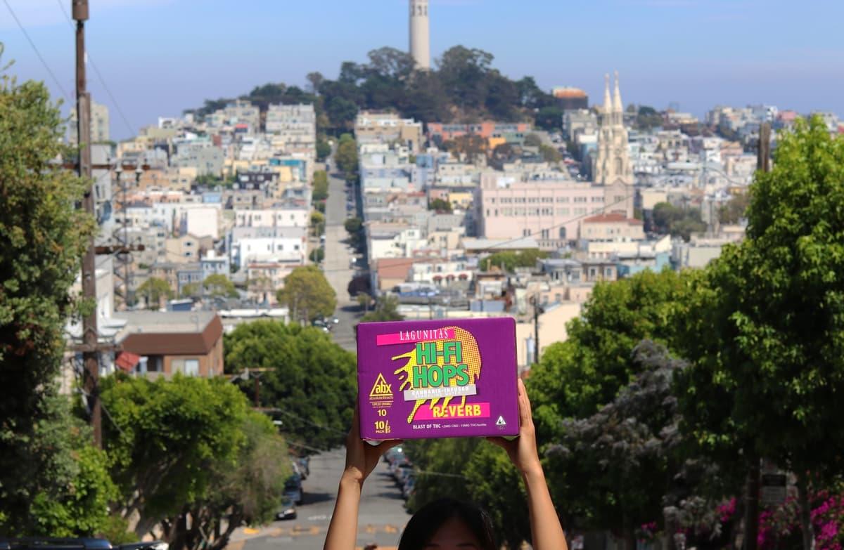 Holding up a case of Hi-Fi Hops with Coit Tower in the background